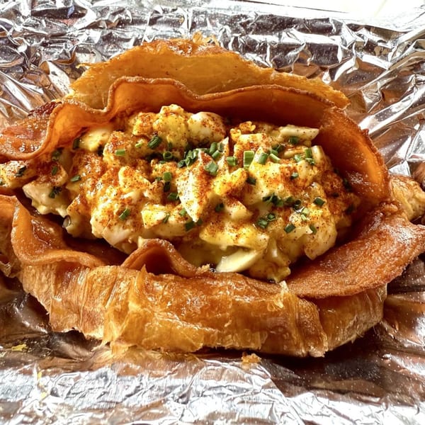 Taiwanese egg salad croissant with chives and paprika, served in aluminum foil.